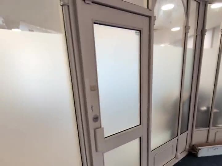 Frosted film on an office partition wall: the glass stays bright and the room beyond stays private