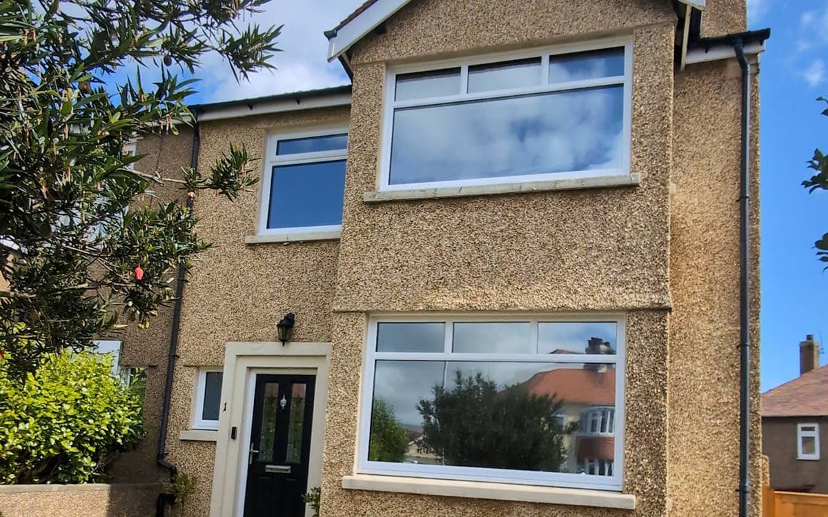 Pebble-dash house with Dual Reflective 20 Premium film fitted — windows have a subtle, low-reflection look