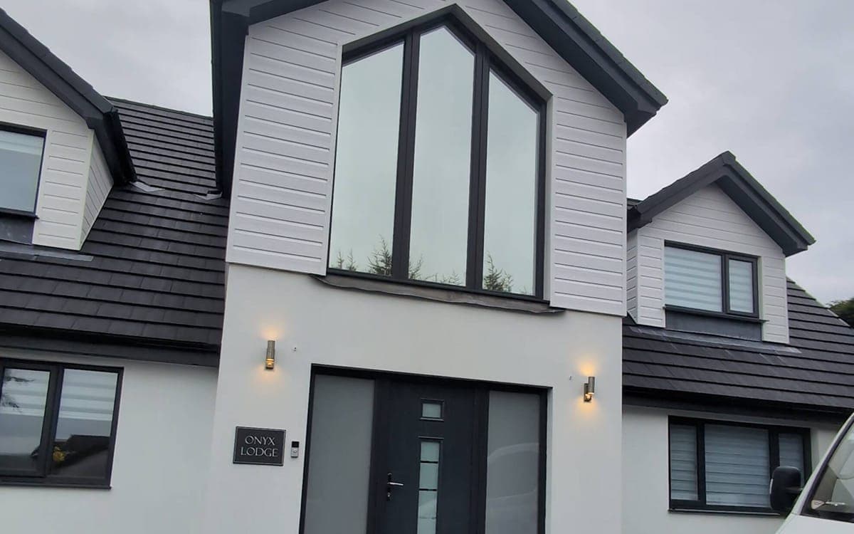 White house with Silver 20 Standard film fitted — windows show a bright mirror finish from outside